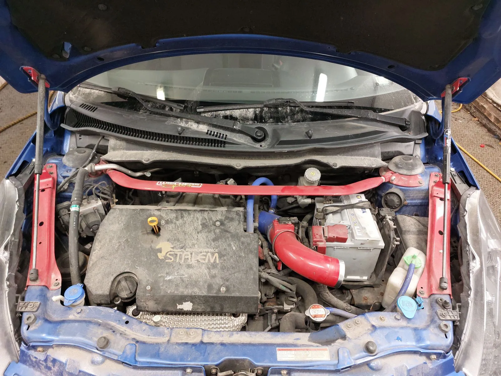 Engine bay before washing, with dust and dirt visible on surfaces.
